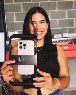 Andrea grabando con su móvil en un almacén